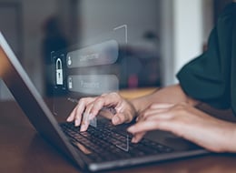 Person entering login information on laptop Person entering login information on laptop